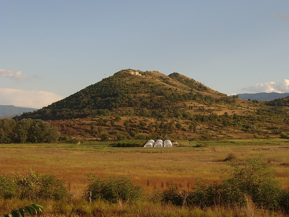 Kozhuh Hill rising above fields near Rupite.