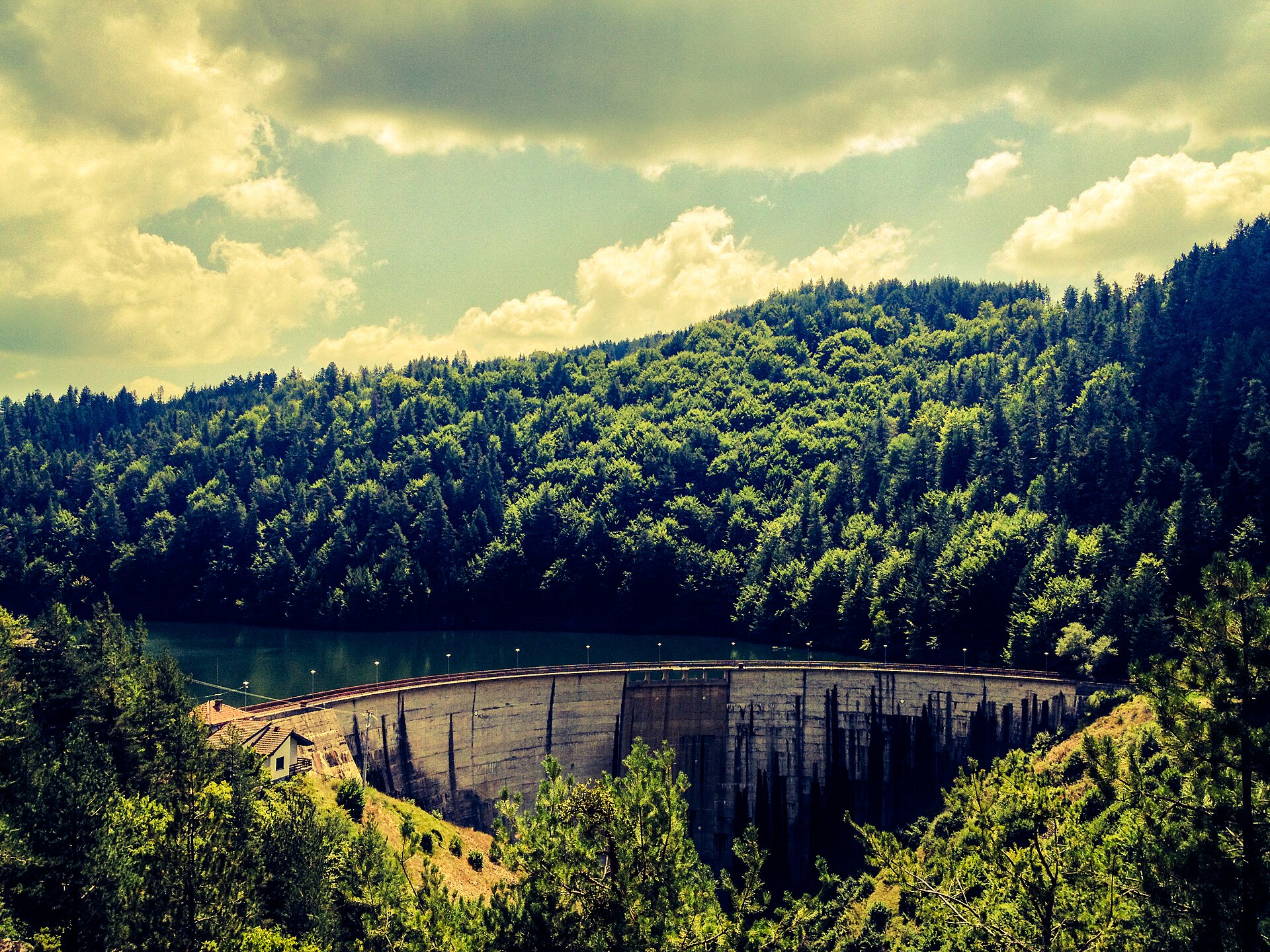 Berovo Lake, its dam and the surrounding wooded hills.
